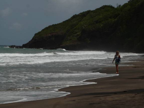 Caminhando pelas areias escuras da praia de Grande Anse, na região de Tròis Rivières, sul de Basse Terre, em Guadalupe Caminhando pelas areias escuras da praia de Grande Anse, na região de Tròis Rivières, sul de Basse Terre, em Guadalupe