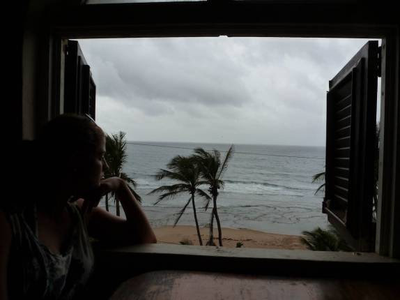 Pensativa, observando a praia e a chuva em Bathsheba, na costa leste de Barbados Pensativa, observando a praia e a chuva em Bathsheba, na costa leste de Barbados