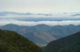 Vista das montanhas e nuvens do mirante da Cachoeira do Aurélio, na trilha capixaba de acesso ao Pico da Bandeira, no Parque Nacional do Caparaó - MG/ES
