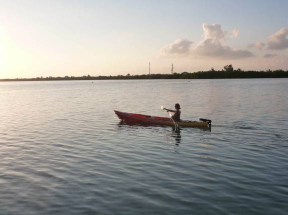 A Ana aproveita o fim de tarde para remar na baía em frente ao nosso hotel em Little Cayman, nas Ilhas Caiman A Ana aproveita o fim de tarde para remar na baía em frente ao nosso hotel em Little Cayman, nas Ilhas Caiman