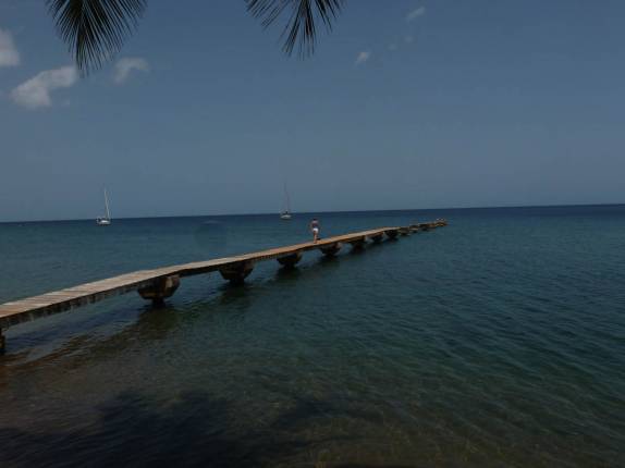 A Ana caminha no pier do nosso hotel em Portsmouth, no norte de Dominica, no Caribe