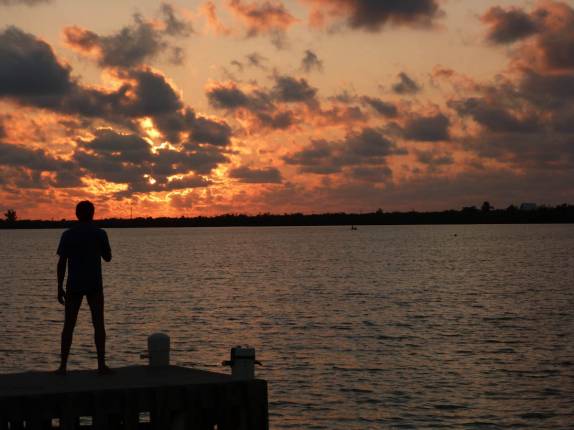 Admirando o espetáculo diário do pôr-do-sol em Little Cayman, nas Ilhas Caiman Admirando o espetáculo diário do pôr-do-sol em Little Cayman, nas Ilhas Caiman
