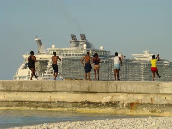 Adolescentes brincando no pier com cruzeiros ao fundo Adolescentes brincando no pier com cruzeiros ao fundo