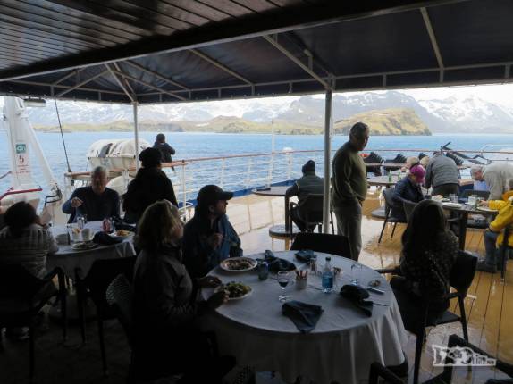 Aproveitando o sol para almoçar ao ar livre no deck do Sea Spirit, saindo de Stromness, na Geórgia do Sul Aproveitando o sol para almoçar ao ar livre no deck do Sea Spirit, saindo de Stromness, na Geórgia do Sul