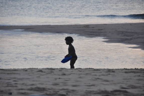 Criança brincando na Ponta do Mutá durante o pôr-do-sol, em Barra Grande, Península do Maraú - BA
