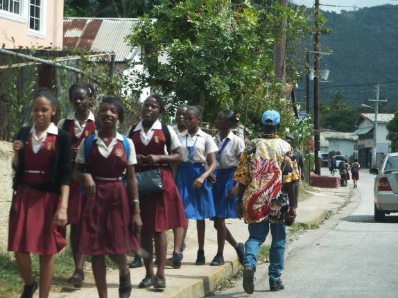 Escolares caminham em rua de pequena cidade na Jamaica
