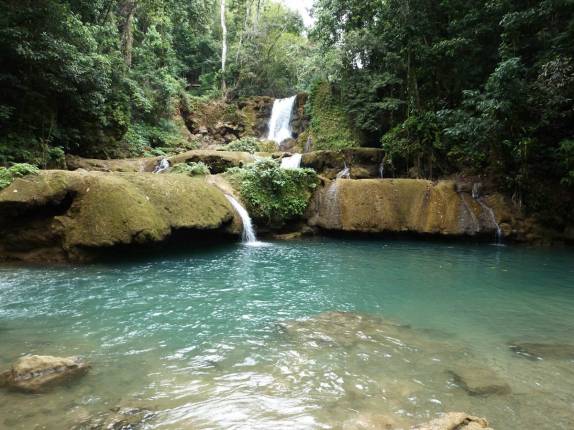 O belíssimo rio de águas azuladas de Ys Falls, no interior da Jamaica O belíssimo rio de águas azuladas de Ys Falls, no interior da Jamaica