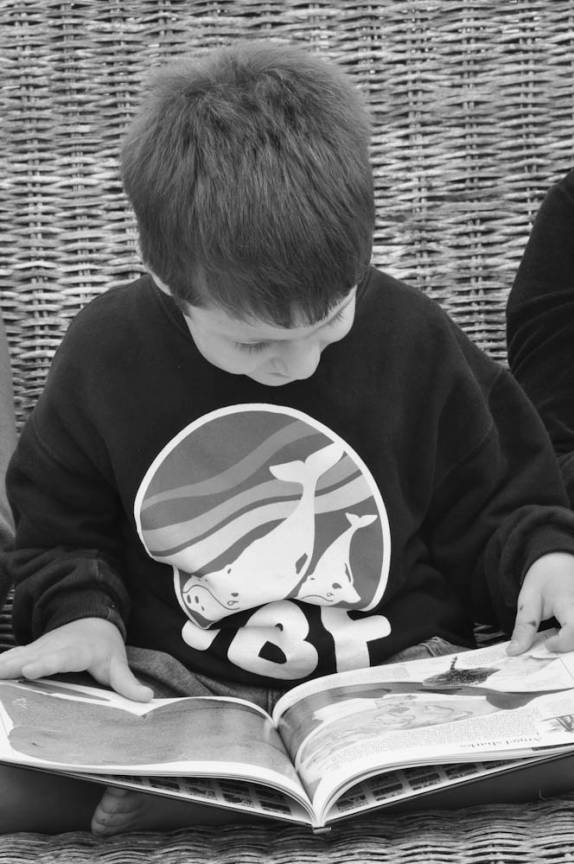 O João lendo um livro sobre tubarões, no barco em direção à Abrolhos - BA