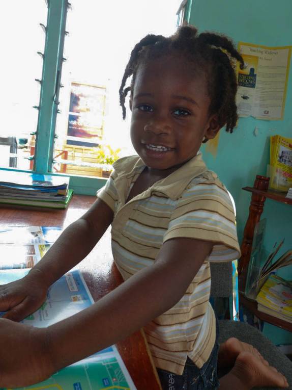 O simpático e irriquieto filho da agente de turismo na oficina do porto de St John's, a capital de Antígua, no Caribe O simpático e irriquieto filho da agente de turismo na oficina do porto de St John's, a capital de Antígua, no Caribe